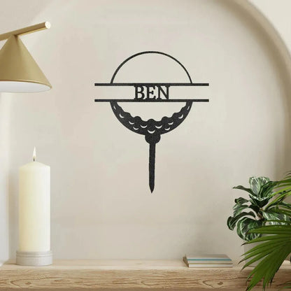 Black metal golf ball monogram wall art with "BEN" inscribed, on a tee.