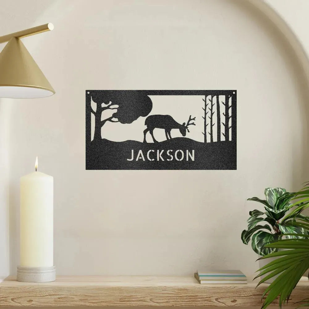 Black metal wall art featuring a grazing deer, trees, and "JACKSON" personalized text.