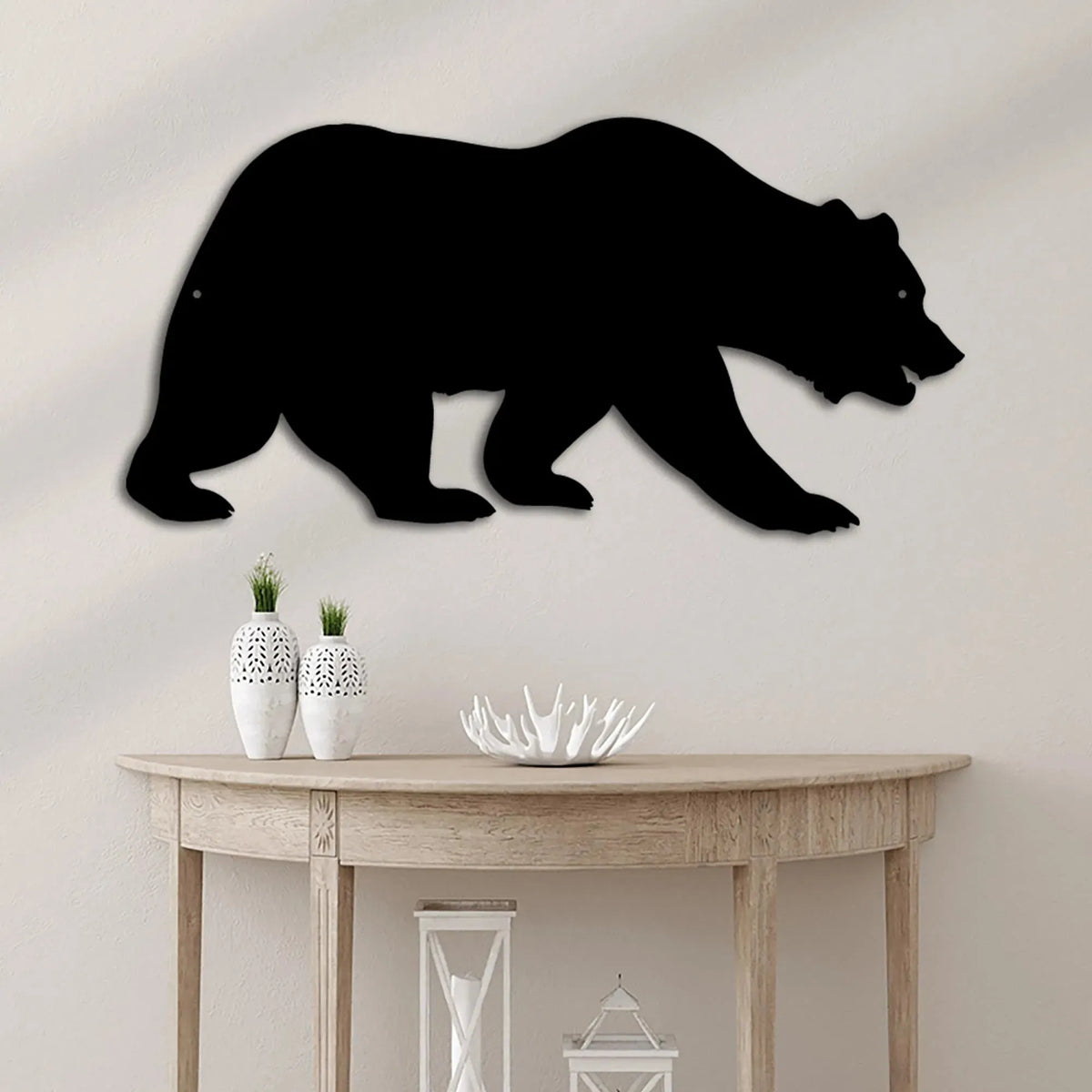 Black metal grizzly bear wall art silhouette above a rustic wooden console table.