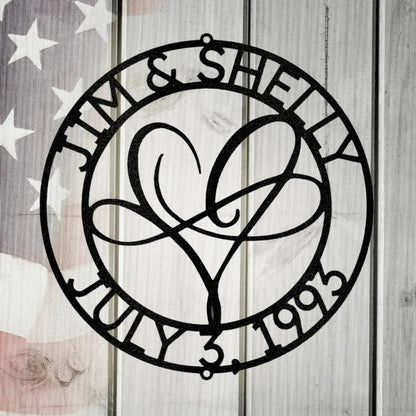 Black metal "Infinite Love Monogram" with names "Jim & Shelly" and date "July 3, 1993" encircling a heart design.