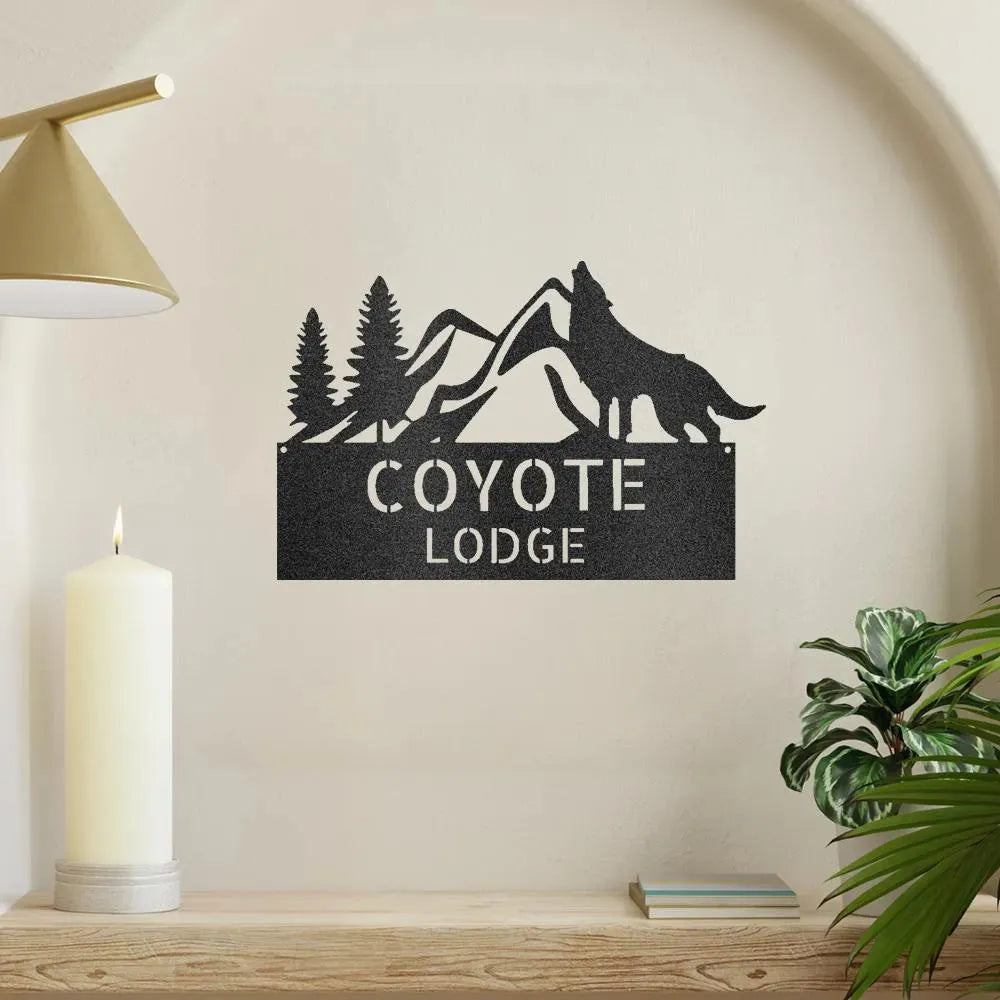 Black metal wall art featuring a howling wolf, pine trees, mountains, and "COYOTE LODGE" text.