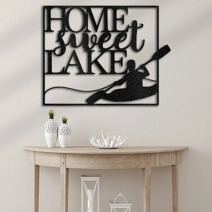 Black metal "Home Sweet Lake" wall art with a kayaker design, displayed above a wooden console table.