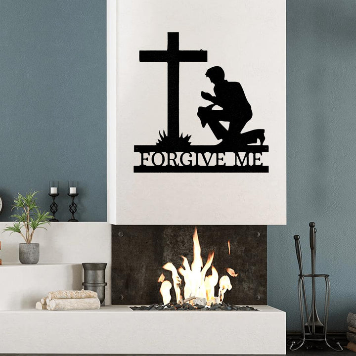 Black metal wall art of a kneeling man before a cross with "FORGIVE ME" text, mounted above a fireplace.