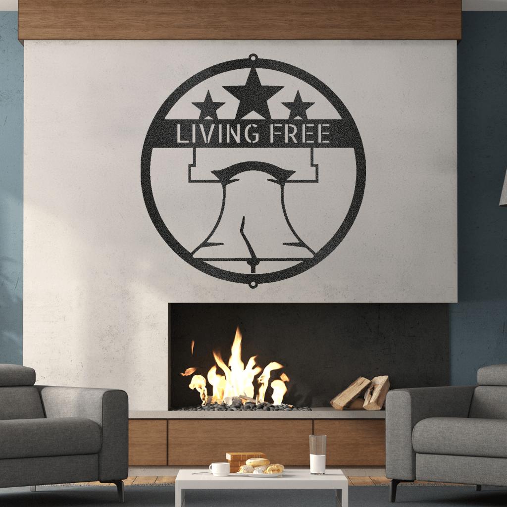Black metal Liberty Bell monogram wall art with "LIVING FREE" text and stars, above a fireplace.