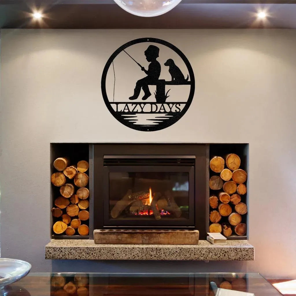 Black metal wall art: boy fishing with dog, "LAZY DAYS" text, in a circular design above a fireplace.