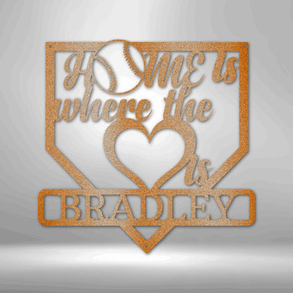 Copper-colored metal baseball home plate sign with "Home is where the heart is" and "BRADLEY" cut out.