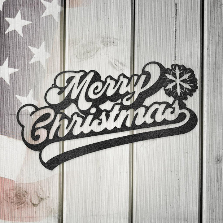 Black metal "Merry Christmas" wall art with snowflake accent on a rustic white wooden background.