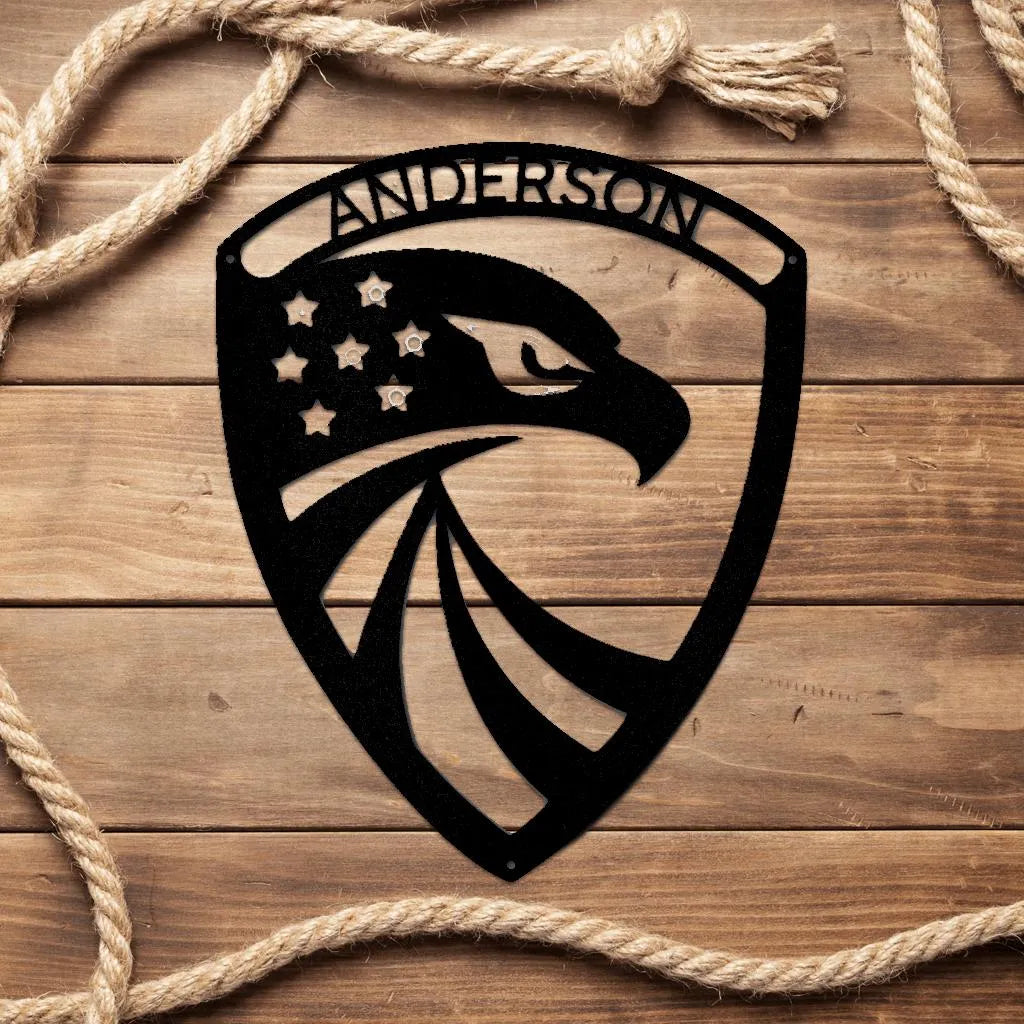 Black metal American eagle shield monogram with "ANDERSON" and stars, on wood.