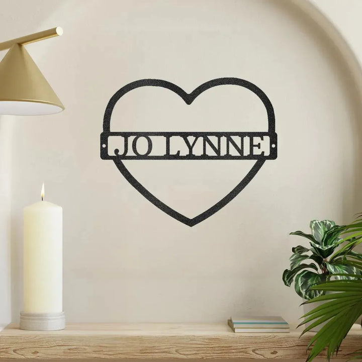 Black metal heart monogram wall art with "JO LYNNE" cutout, displayed on a light wall.