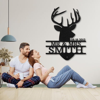 Black metal deer head monogram with "08.18.2012 MR & MRS SMITH" above a couple.