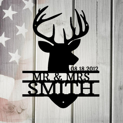 Black metal deer head monogram with "MR. & MRS. SMITH" and "08.18.2012" on a rustic American flag background.