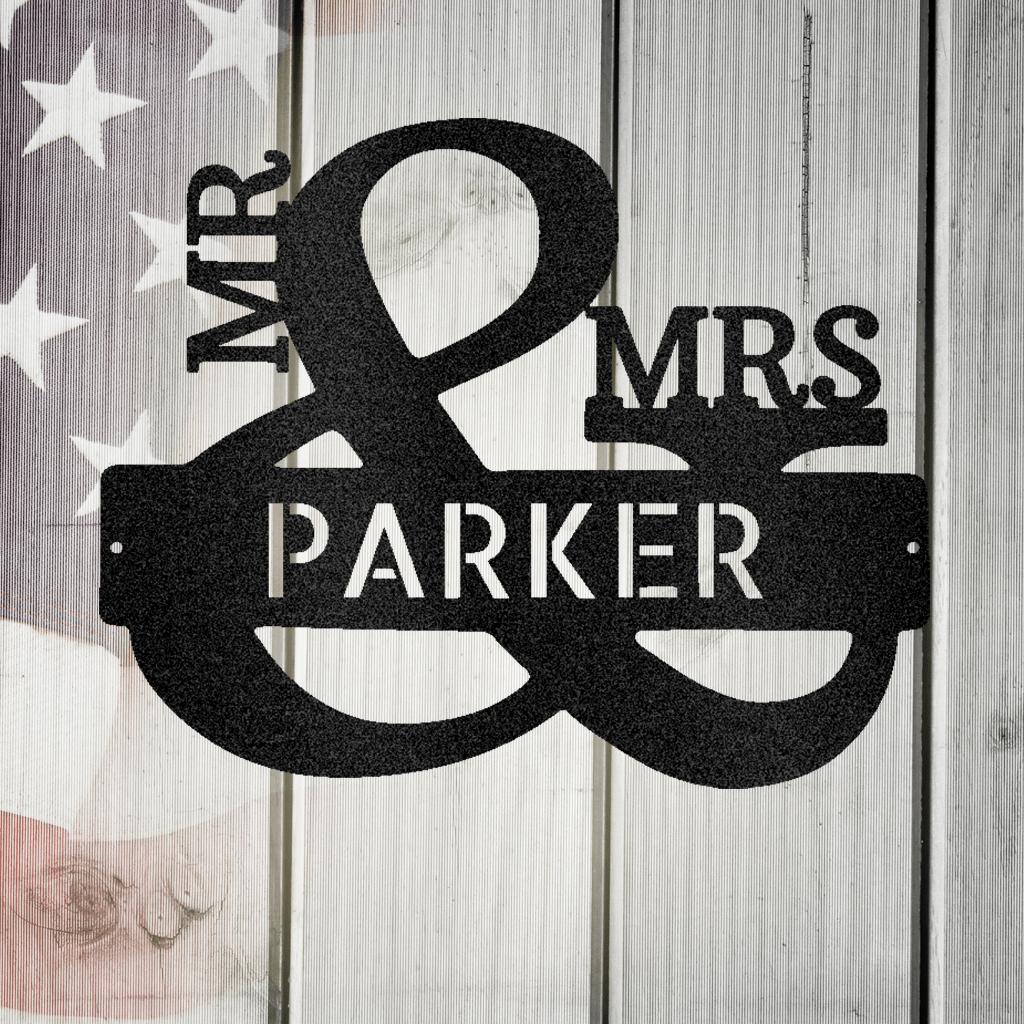 Black metal "Mr. & Mrs. Parker" personalized wall art on a white wooden background with an American flag.
