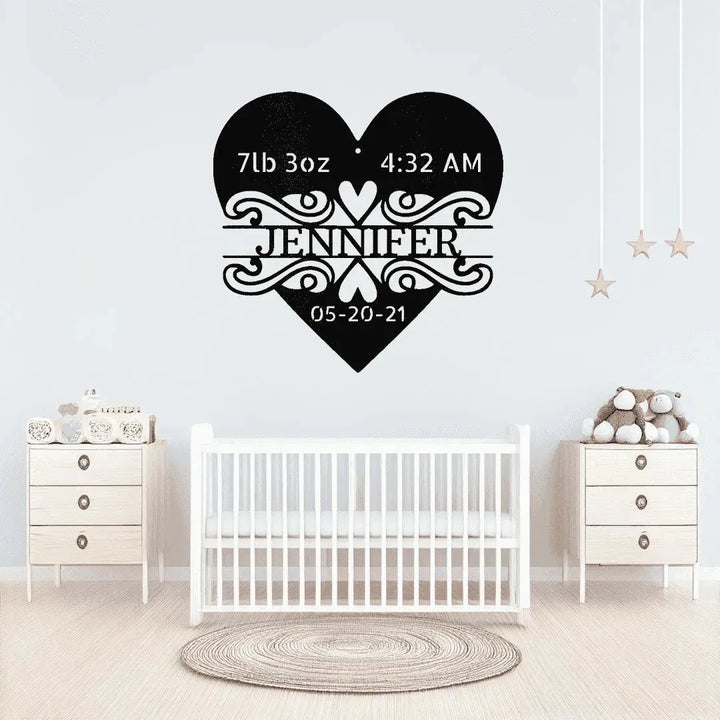 Black metal heart monogram with "Jennifer," birth weight, time, and date, above a white crib.