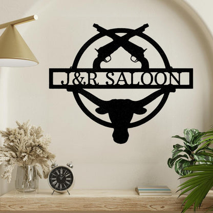Black metal Old School Saloon Monogram wall art featuring crossed revolvers, a longhorn skull, and custom text.