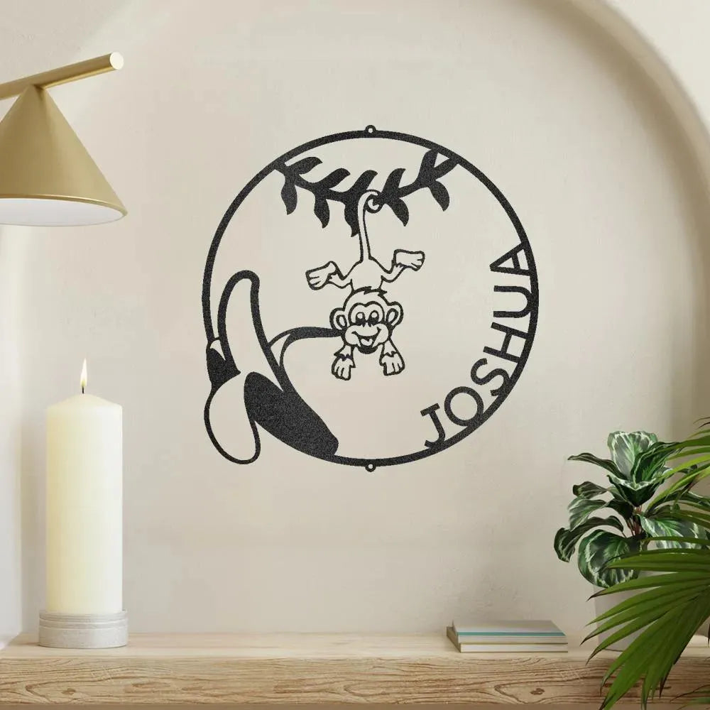 Black metal wall art with a monkey, banana, and "Joshua" in a circular design.