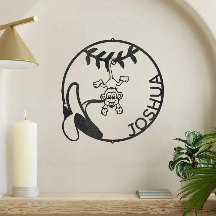 Black metal wall art with a monkey, banana, and "Joshua" in a circular design.