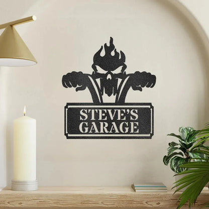 Black metal wall art with a flaming skull, motorcycle handlebars, and "STEVE'S GARAGE" text.
