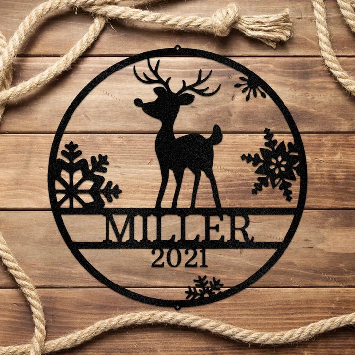 Black metal Rudolph reindeer monogram wall art with "MILLER 2021" text, snowflakes, on wood with rope.