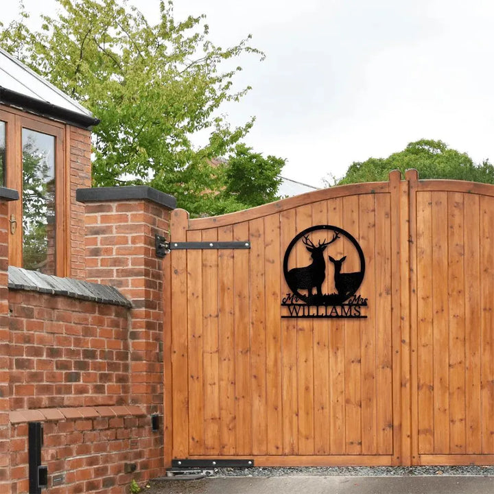 Black metal stag and doe monogram with "Mr & Mrs Williams" on a wooden gate.
