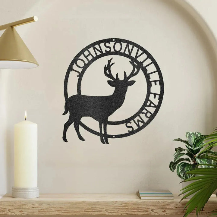 Black metal stag monogram wall art with "JOHNSONVILLE FARMS" text, displayed on a beige wall.