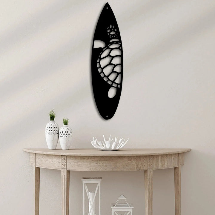 Black metal surfboard wall art with a white cutout sea turtle design.