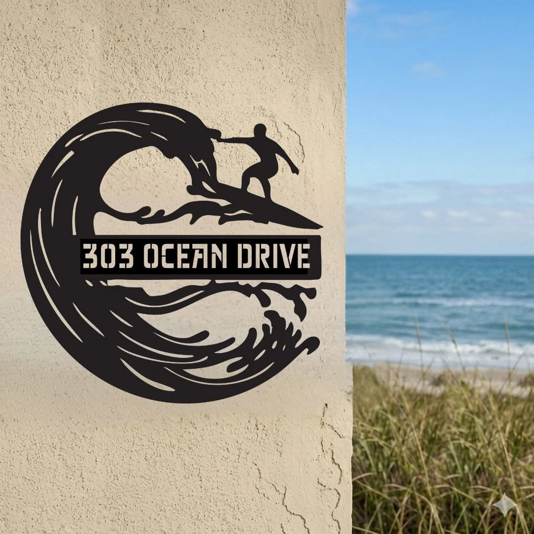 Decorative metal sign with wave and surfer design on a wall with ocean view