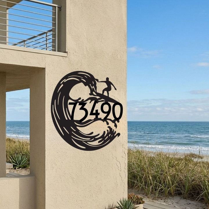 Decorative metal wall art with a wave design and numbers on a beachside building.