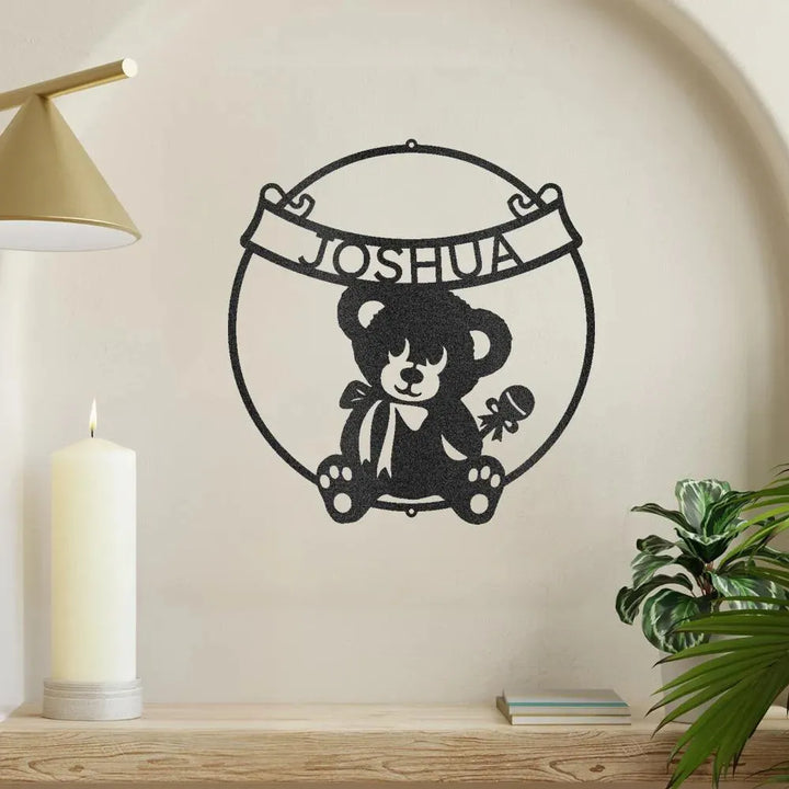 Black metal teddy bear banner monogram wall art with "JOSHUA" above a sitting bear holding a rattle.