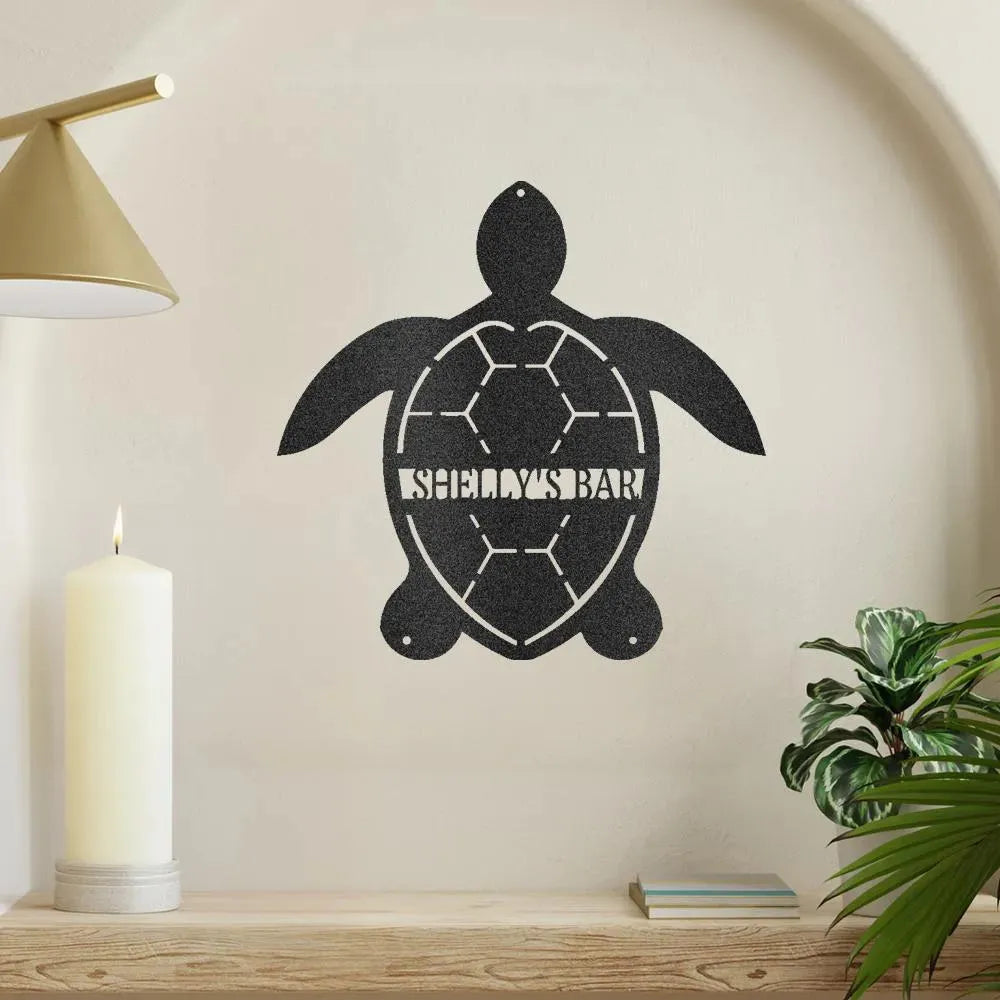 Black metal turtle monogram wall art with "SHELLY'S BAR" on a light wall.